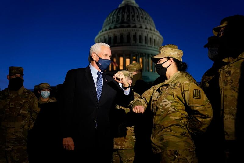 Vice President Mike Pence elbow bumps with a member of the National Guard as he speaks to troops outside the US Capitol. AP Photo