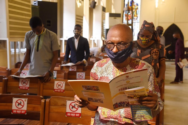 Worshippers wear face masks as they attend a mass following the reopening of churches and lifting of restrictions on religious gatherings in Lagos, on August 9. Pius Utomi Ekpei / AFP