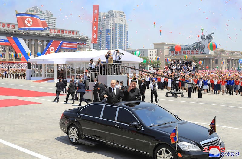 Mr Putin and Mr Kim wave during the official welcome ceremony at the Kim Il-sung Square in Pyongyang. AP