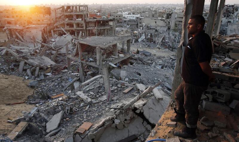 A Palestinian man in the ruins of his house looks out over what is left of his neighbourhood in the eastern districts of Gaza City that witnesses said was destroyed during the Israeli offensive. Suhaib Salem / Reuters