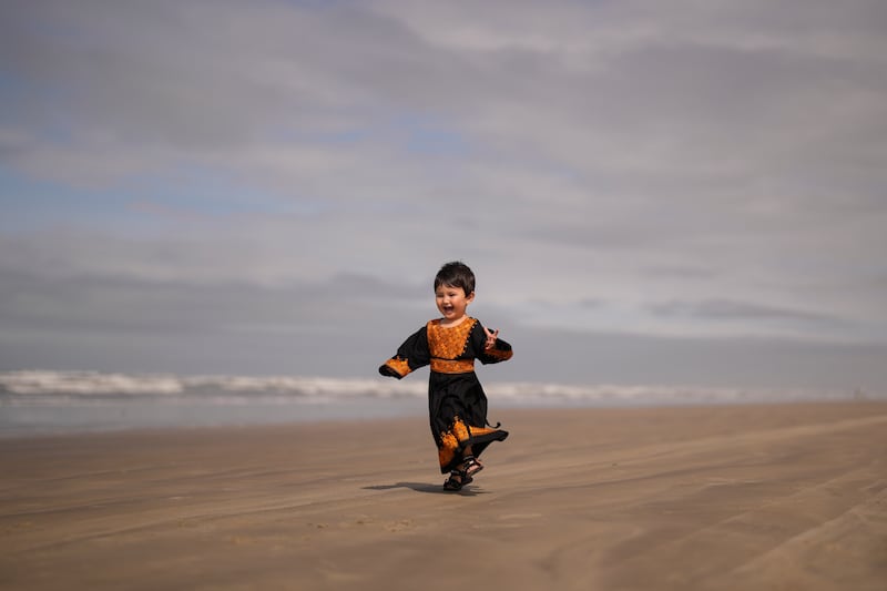 An Afghan refugee, 2, enjoys the beach in Praia Grande, Sao Paulo, Brazil. AP