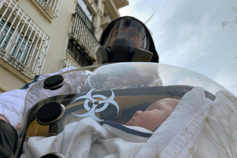Cao Junjie poses for a picture with his two-month old baby inside a safety pod he created to protect his baby from the coronavirus disease (COVID-19), at a residential compound in Shanghai, China. REUTERS