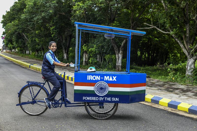Indian teenager Vinisha Umashankar driving a cart with the solar-powered iron that she designed. PA