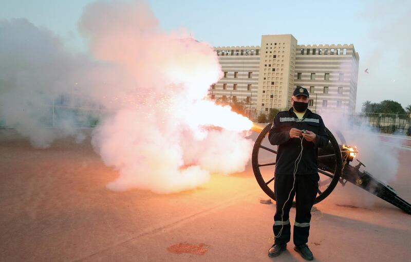 Egyptian policeman Mohamed Nasser, wearing a face mask, fires a Ramadan cannon, a traditional cannon that was used in the earlier days to announce breaking fast time, in Cairo, Egypt. EPA