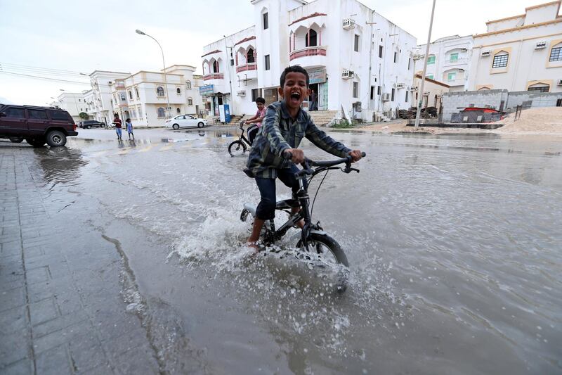 A child plays in a roadside puddle accumulated from rain brought by Cyclone Luban in Salalah, Oman, October 13, 2018. REUTERS/Stringer