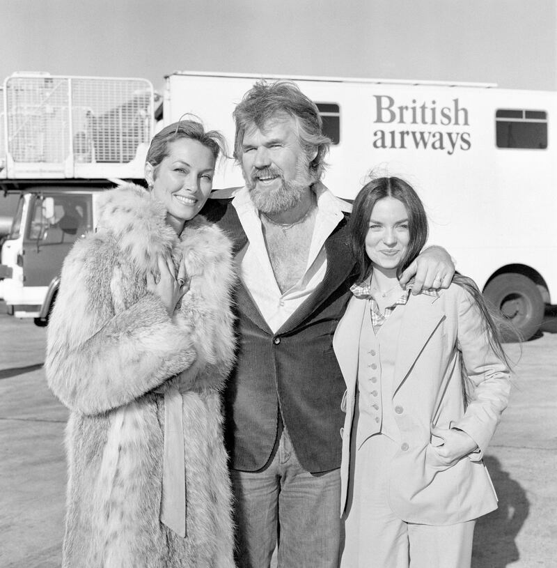 PA via Reuters
American singing star Kenny Rogers at London's Heathrow airport when he arrived with his two favourite ladies - his bride of a few weeks, television star Marianne Gordon (left) and the lovely Crystal Gayle.