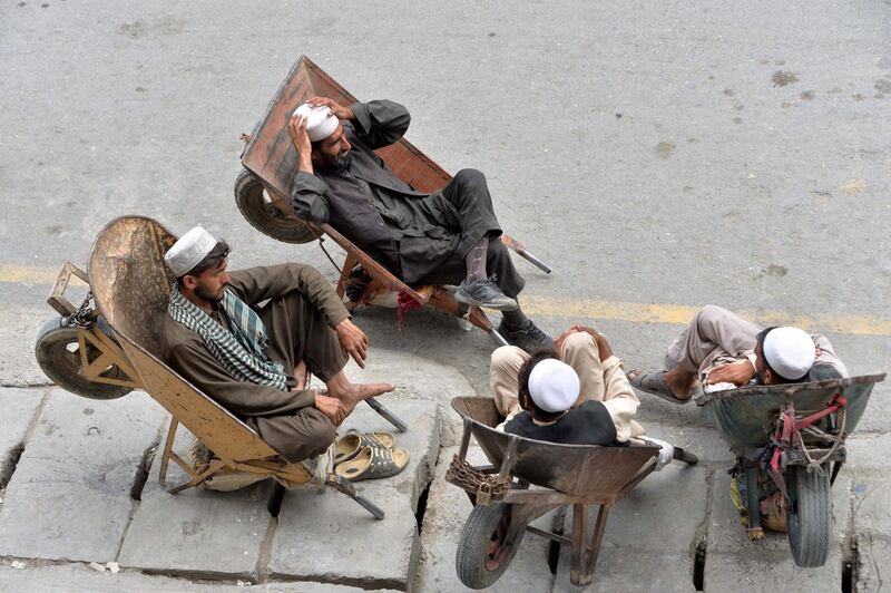 Afghan labourers rest in their wheelbarrows on a street in Jalalabad. AFP