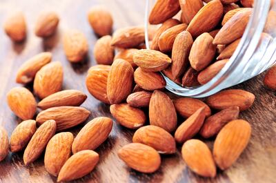 Raw almonds spilling out of small glass bowl (iStockphoto.com)