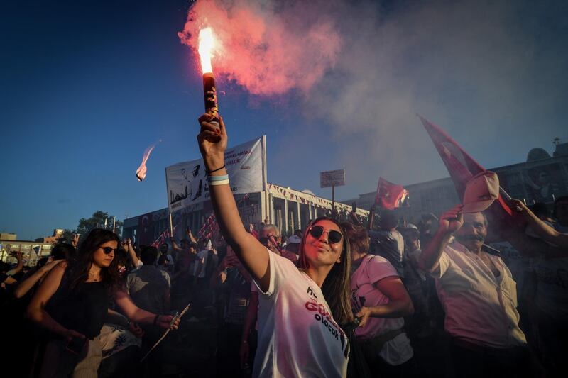A supporter of Mr Imamoglu holds up a flare during celebrations of the opposition candidate becoming Istanbul mayor. Getty Images