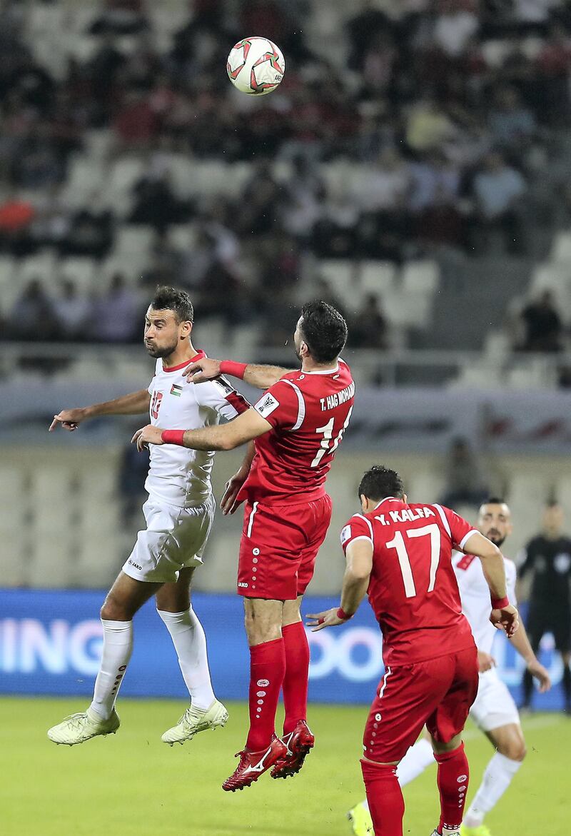 SHARJAH , UNITED ARAB EMIRATES , January  6 ��� 2019 :- Sameh Maraaba ( no 10 in white ) of Palestine and Abdallah Jaber ( no 14 in red ) of Syria in action during the AFC Asian Cup UAE 2019 football match between Syria vs Palestine held at Sharjah Football Stadium in Sharjah. ( Pawan Singh / The National ) For News/Sports