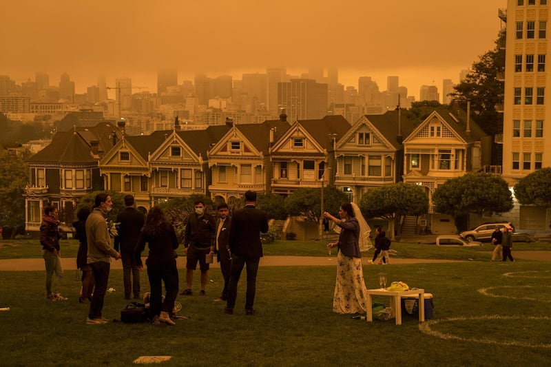 People stand in Alamo Square Park as smoke hangs over San Francisco, California, U.S. Bloomberg