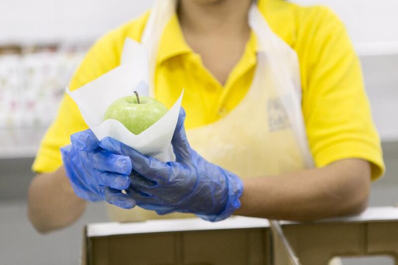 A staff does one final check of the fruit’s quality before wrapped it is readied for delivery. Reem Mohammed / The National