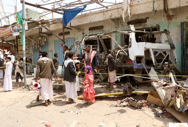 People gather next to the wreckage of a bus at the scene of Thursday's air strike in Saada province, Yemen August 11, 2018. REUTERS/Naif Rahma