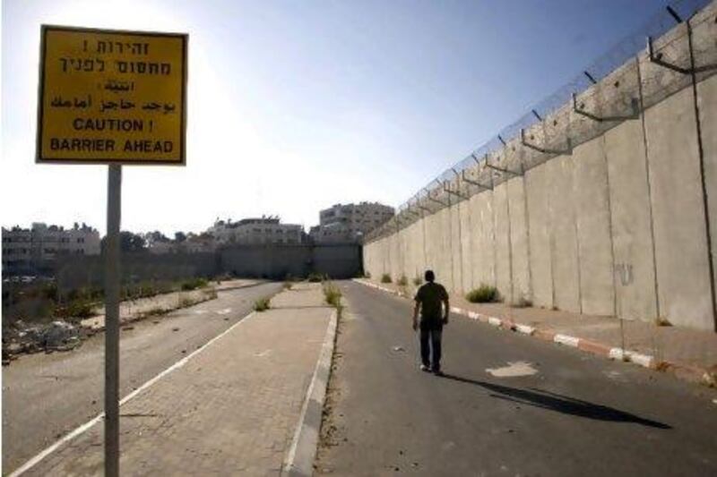 Much of the West Bank celebrated when Mahmoud Abbas submitted Palestine's application for full membership in the UN. But what happens now? Above, a Palestinian man walks alongside the concrete barrier that separates the Israeli-occupied West Bank from East Jerusalem.