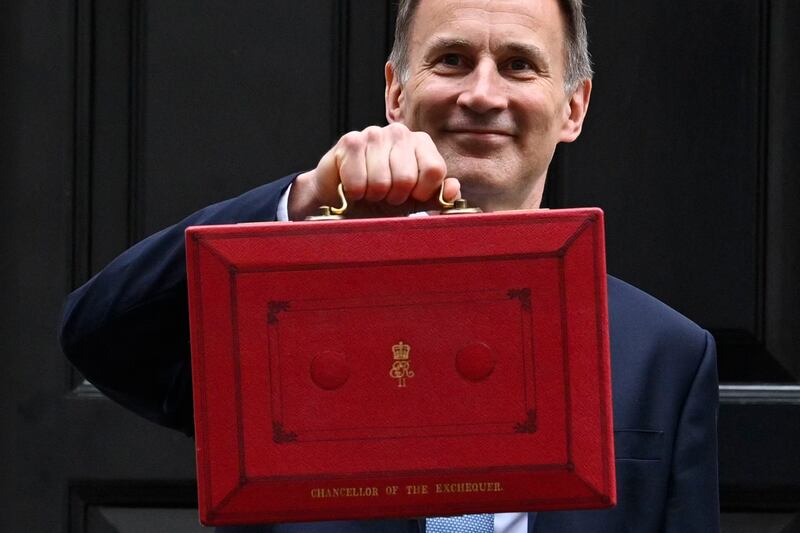 Jeremy Hunt leaves No 11 Downing Street with the red budget box on Wednesday. AFP