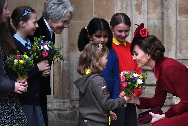 Britain's Catherine, Duchess of Cambridge, right, receives flowers from a child after the annual Commonwealth Service at Westminster Abbey. EPA
