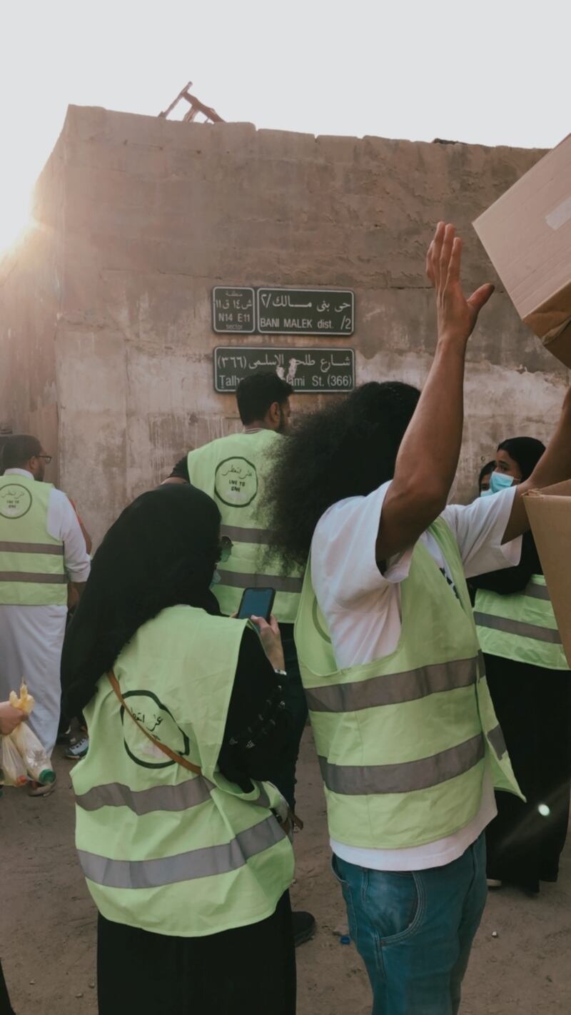 Volunteers gather boxes containing essential supplies, such as cooking oil, rice and sugar.