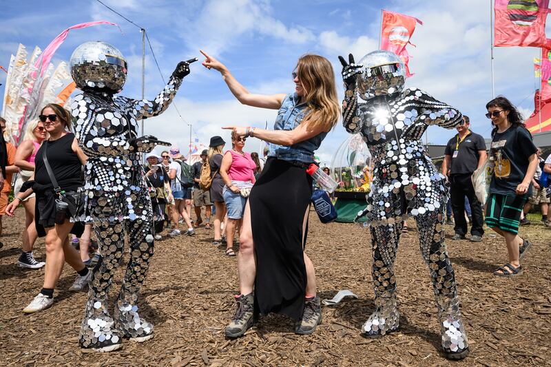 Dancers in mirrorball costume mingle with revellers as the Glastonbury Festival is in full swing. Getty Images