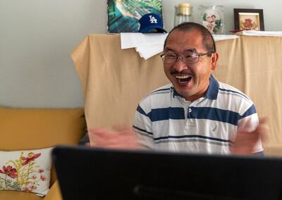 Associated Press photographer Ringo H.W. Chiu celebrates after learning he won the Pulitzer Prize via video conferencing from his home in Los Angeles Friday, June 11, 2021. Chiu is one of ten AP photographers who won the 2021 Pulitzer Prize for breaking news photography. (AP Photo/Damian Dovarganes)