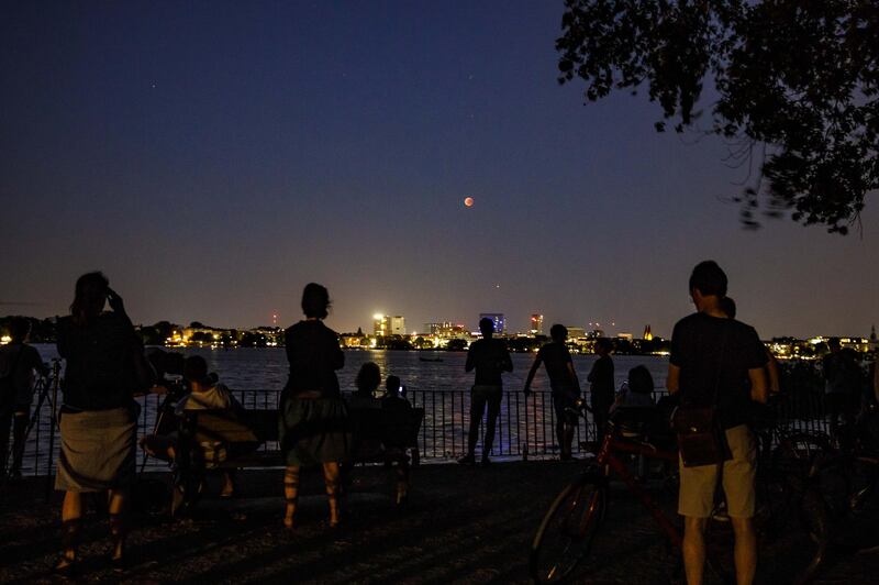People gather at the Alster Lake to watch the 'blood moon' eclipse over the northern German city of Hamburg. Getty Images