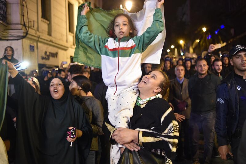 People carry a national flag as they celebrate on the streets after Mr Bouteflika submitted his resignation, in Algiers, April 2, 2019. AFP