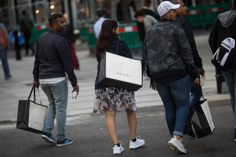 Shoppers carry Gucci Ltd. luxury goods shopping bags as they walk along New Bond Street in central London, U.K., on Thursday, Aug. 31, 2017. U.K. consumer confidence staged a slight rebound from its lowest level since just after the Brexit vote. Photographer: Simon Dawson/Bloomberg