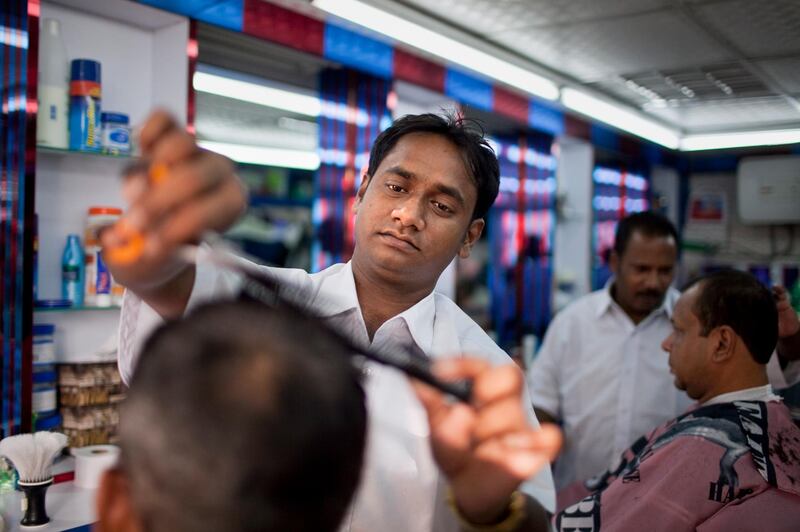 Barber Mintu Kumar Shin skillfully cuts a customer's hair at the Hafila Men's Salon in the Khalidiya neighborhood in Abu Dhabi on Sunday, July 31, 2011, the last day before the start of Ramadan. (Silvia Razgova/The National)

