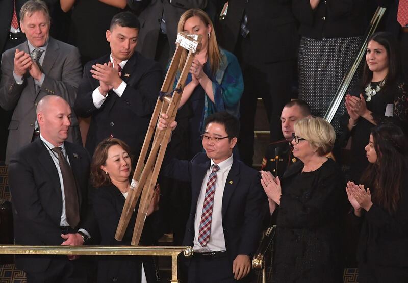 North Korean defector Ji Seong-ho raises his crutches as he is recognised by US President Donald Trump during the State of the Union address. Mandel Ngan / AFP