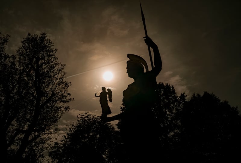 A statue of goddess Minerva is backdropped by the sun during a partial solar eclipse in Bucharest. AP