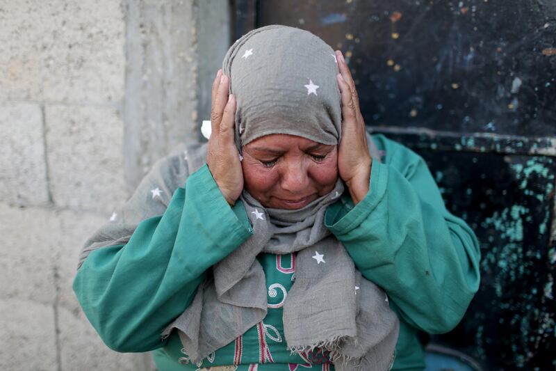 A Palestinian woman reacts as she sits outside her home in the southern Gaza Strip. Reuters