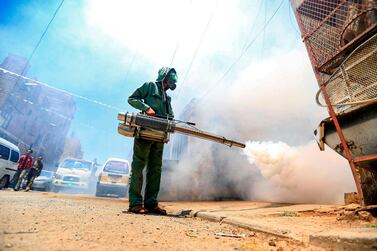 TOPSHOT - A government worker that is part of a combined taskforce tackling COVID-19 coronavirus fumigates a neighbourhood as part of safety precautions, in Yemen's capital Sanaa on March 23, 2020. / AFP / Mohammed HUWAIS