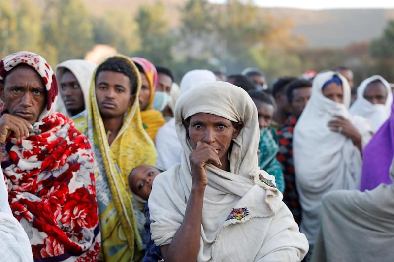 A woman stands in line to receive food donations at the Tsehaye primary school, which was turned into a temporary shelter for people displaced by conflict, in the town of Shire, Tigray region. Reuters