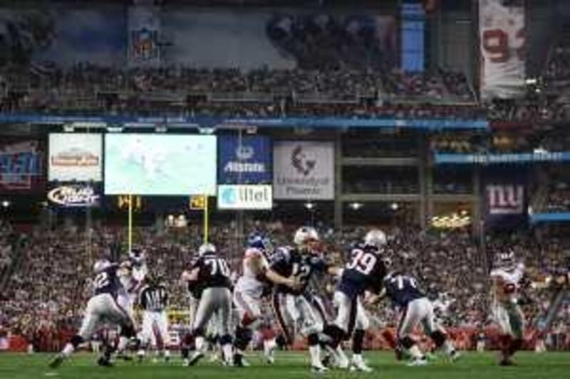 GLENDALE, AZ - FEBRUARY 03:  Quarterback Tom Brady #12 of the New England Patriots hands the football off to running back Laurence Maroney #39 of the New York Giants in the second quarter during Super Bowl XLII on February 3, 2008 at the University of Phoenix Stadium in Glendale, Arizona.  (Photo by Harry How/Getty Images)