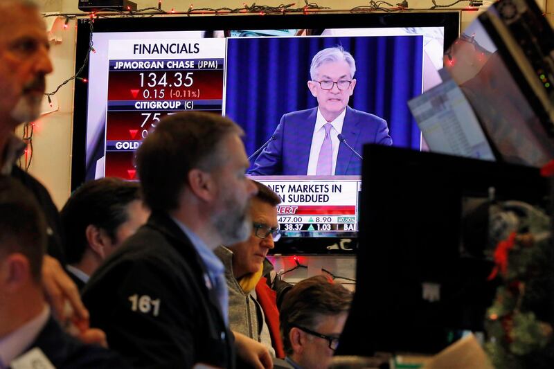 A television screen on the floor of the New York Stock Exchange shows Federal Reserve Board Chair Jerome Powell's Washington news conference, Wednesday, Dec. 11, 2019. The Federal Reserve is leaving its benchmark interest rate alone and signaling that it expects to keep low rates unchanged through next year. (AP Photo/Richard Drew)