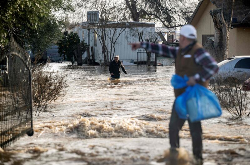 Residents scramble to retrieve belongings before flood waters rise too high in Merced. AFP