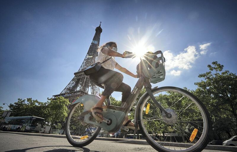 PARIS, FRANCE - AUGUST 04: A cyclist rides past the Eiffel Tower on one of the 20,000 Velib rental bikes available in Paris on August 04, 2020 in Paris, France. Since the end of lockdown the number of cyclists in Paris has risen by nearly 50 percent as authorities have encouraged cycling as a safer, and more environmentally friendly form of transport away from crowded buses and metro trains as they continue to try to halt the spread of COVID-19. Mayor Anne Hidalgo has added a further 31 miles of roadway in the city for bikes with the promise of making Paris a cycling capital.  (Photo by Kiran Ridley/Getty Images)