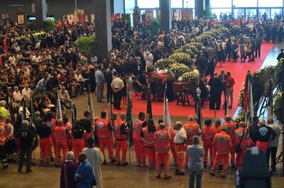 epa06955536 Victims of the Morandi bridge disaster lie in coffins at the Fiera di Genova exhibition centre prior to the State funeral, in Genoa, Italy, 18 August 2018. The Morandi bridge partially collapsed on 14 August, killing at least 41 people.  EPA/LUCA ZENNARO