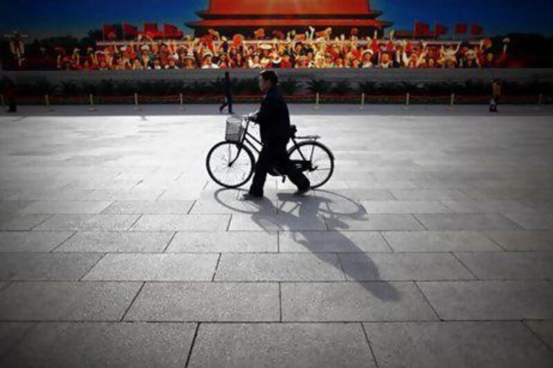 Chinese executives are buying bicycles with price tags of almost Dh60,000. Above, a man walks his bike at Beijing's Tiananmen Square. Carlos Barria / Reuters