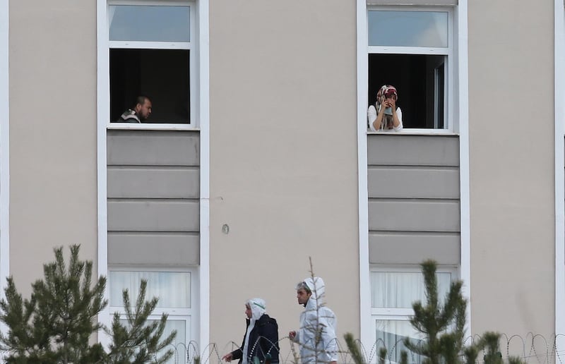 Turkish citizens look out from windows in Ankara after being  quarantined to prevent the spread of coronavirus  after returning from Saudi Arabia, where they took part in the Umrah pilgrimage.  EPA