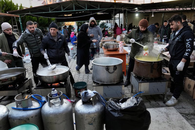 Volunteers cook for Syrians at a shelter in Antakya. AP 