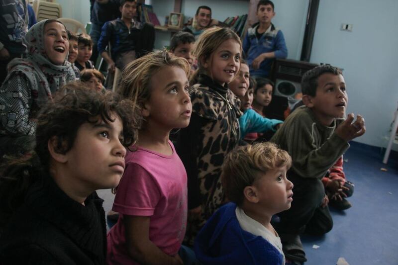 Refugee children at a refugee camp in Lebanon watch a magic show in Syria. Courtesy Magic for Smiles