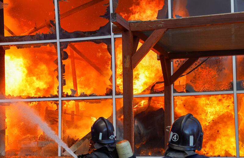 Firefighters work to extinguish flames at a shopping centre Galaktika after Russian shelling in Donetsk. Reuters