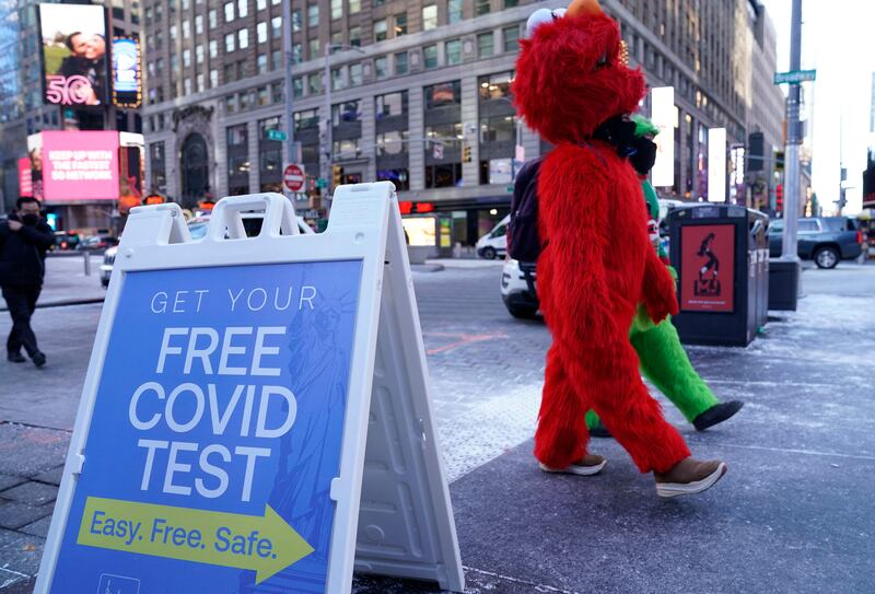 Mascots walk past a sign for Covid-19 tests in New York City. AFP