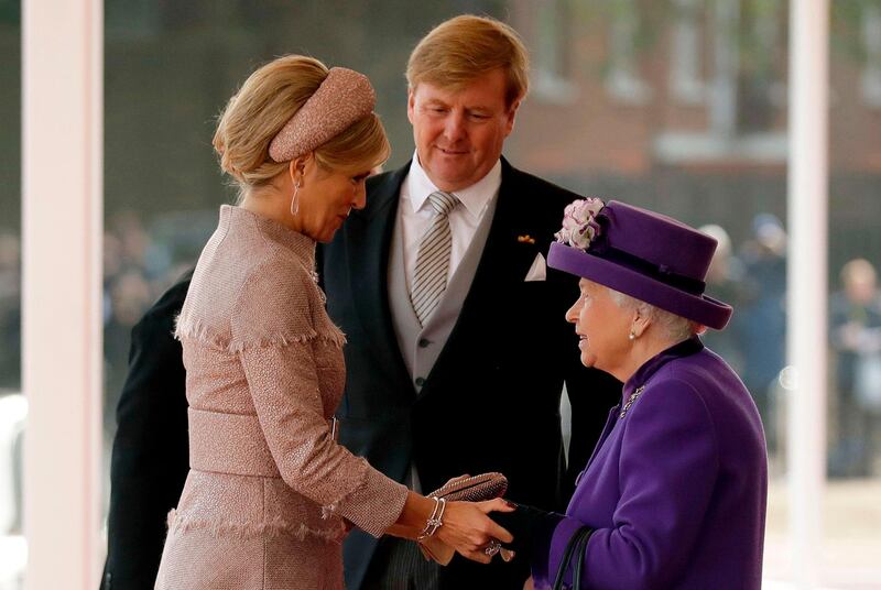 King Willem-Alexander, centre, and Queen Maxima, left, of the Netherlands, are greeted by Britain's Queen Elizabeth II during a Ceremonial Welcome on Horse Guards Parade in London. Matt Dunham / AFP