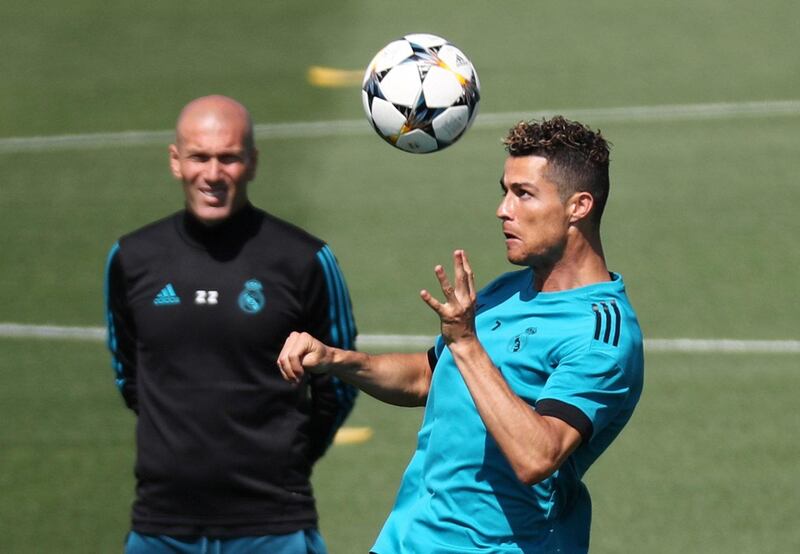 Real Madrid forward Cristiano Ronaldo heads the ball in training as Zinedine Zidane looks on. Sergio Perez / Reuters