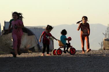 Displaced Iraqi children from the minority Yazidi sect, who fled the Iraqi town of Sinjar, play at the Khanki camp on the outskirts of Dohuk province in 2019. Reuters 