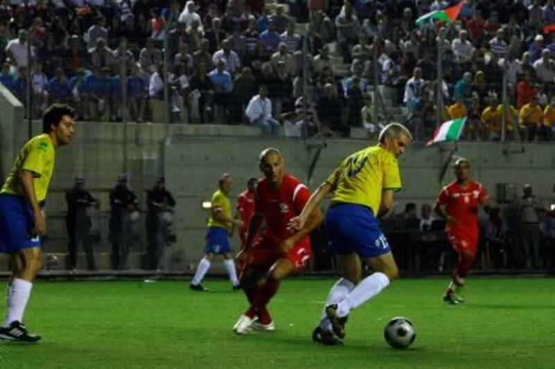 The Palestinian national football squad takes on a team of visiting Catholic priests (yellow T-shirts) from Italy in a friendly match at the Al-Khader Stadium outside the West Bank biblical town of Bethlehem on October 26, 2010. AFP PHOTO/MUSA AL-SHAER

 *** Local Caption ***  508101-01-08.jpg
