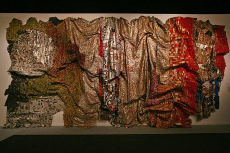 The Ghanaian artist El Anatsui's In the World But Don't Know the World is made of thousands of crimped and flattened pieces of scrap metal.