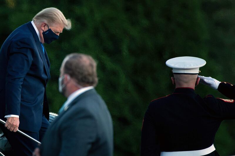 TOPSHOT - US President Donald Trump walks off Marine One while arriving at Walter Reed Medical Center in Bethesda, Maryland on October 2, 2020, after testing positive for covid-19.
 President Donald Trump will spend the coming days in a military hospital just outside Washington to undergo treatment for the coronavirus, but will continue to work, the White House said Friday / AFP / Brendan Smialowski
