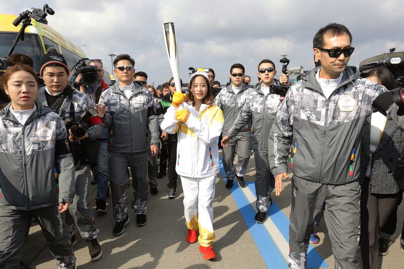 INCHEON, SOUTH KOREA - NOVEMBER 01:  First torch bearer, South Korean figure skater You Young runs as she hold the PyeongChang 2018 Winter Olympics torch during a torch relay on November 1, 2017 in Incheon, South Korea.  (Photo by Chung Sung-Jun/Getty Images)